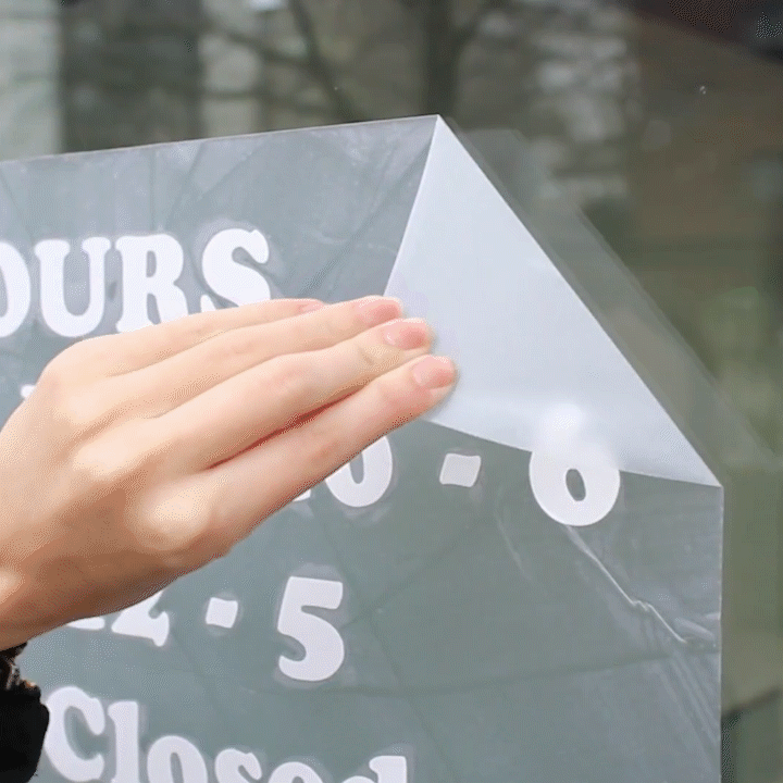 Vinyl window lettering being applied to a store window